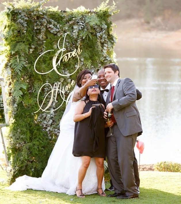 Wedding couple standing by the lake taking selfies