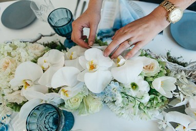 Person arranging flowers on a table